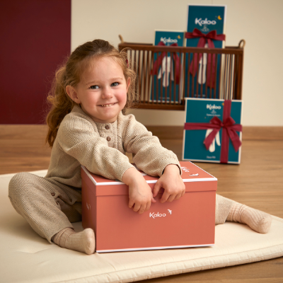 Petite fille tenant un coffret cadeau Kaloo